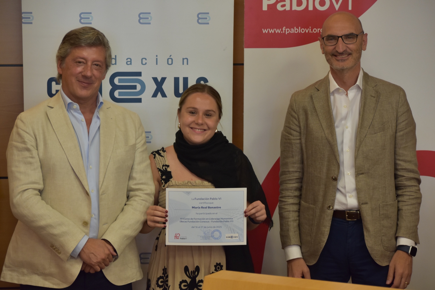 El director de Conexus, Enrique Sánchez de León, y el director general de la Fundación Pablo VI, Jesús Avezuela, entregan el diploma a una María Real Bonastre